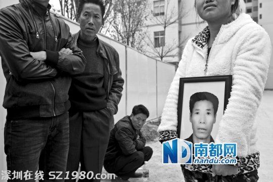 在新塘派出所門口，女兒拿著父親劉先生的遺像為其討公道。 南都記者 黎湛均 攝