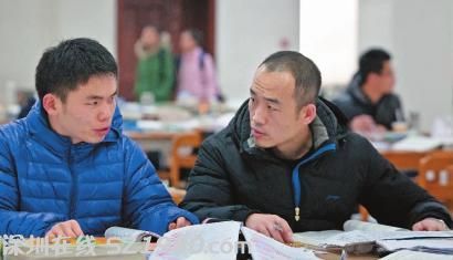 圖書館自習(xí)室，34歲的大學(xué)生楊井堂（右）和同學(xué)探討問題 本報記者 蔣盛松 攝