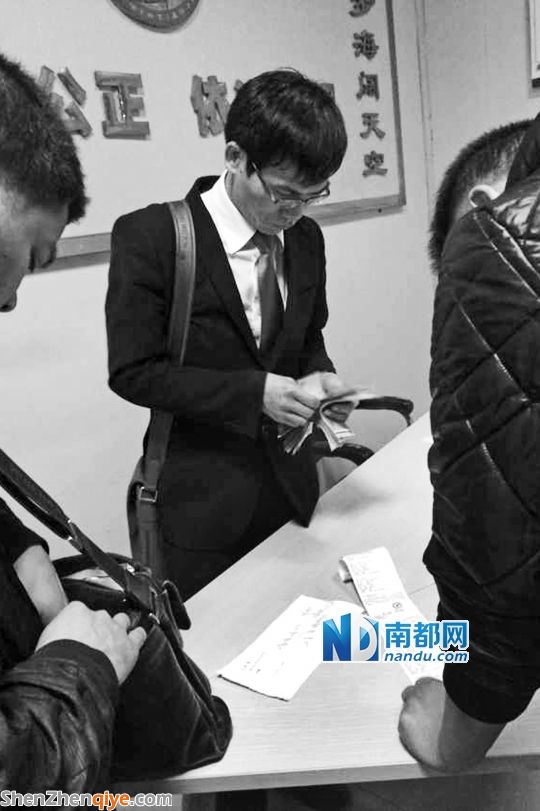 <p> 3月13日，與梁先生的撞車事故調(diào)解獲得賠償后，徐某在大浪交警中隊(duì)調(diào)解室數(shù)錢。</p><p> 南都記者 陳文才翻拍</p>