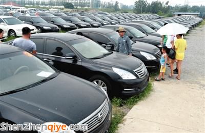 昨日，市民在山東棗莊一家拍賣公司場地上查看待拍賣公車。當(dāng)日，棗莊市103輛公車公開拍賣。新華社記者 馮杰 攝