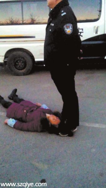 事發(fā)現(xiàn)場(chǎng)一名身穿警服的男子疑似用腳踩著女農(nóng)民 工周秀云的頭發(fā)（12月13日攝）。